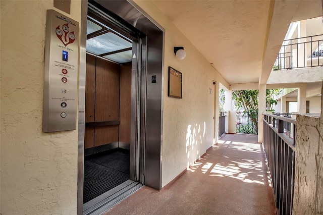 view of exterior entry featuring elevator and stucco siding