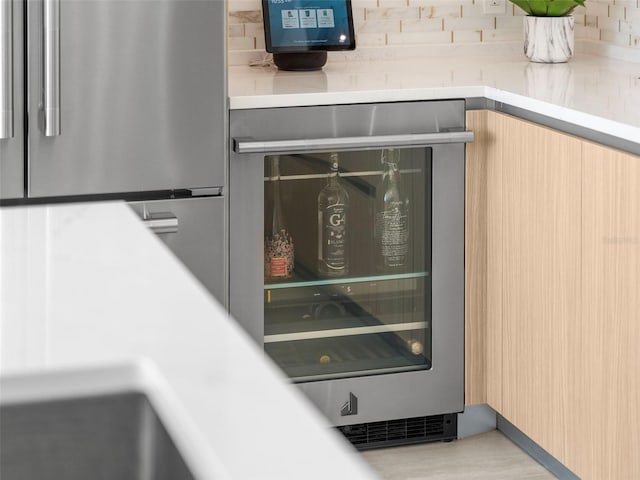 details with beverage cooler, light countertops, and freestanding refrigerator