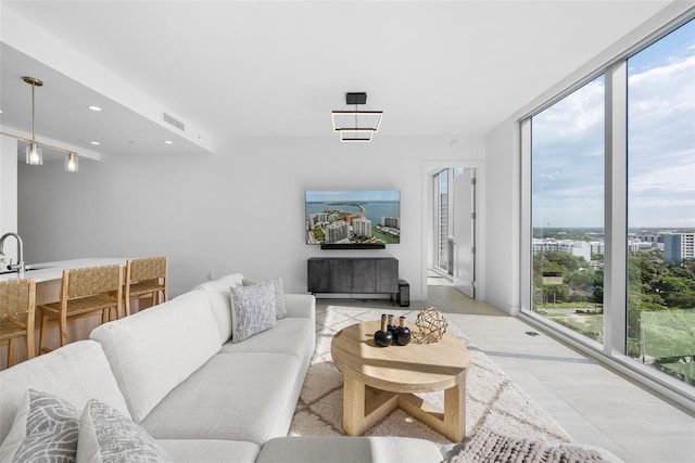 living area featuring a wall of windows, visible vents, and recessed lighting