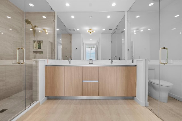 full bathroom featuring a sink, double vanity, a shower stall, and recessed lighting