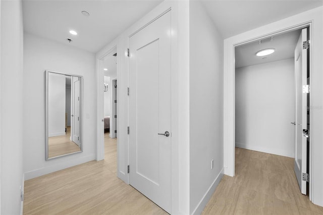 hall with light wood finished floors, recessed lighting, and baseboards