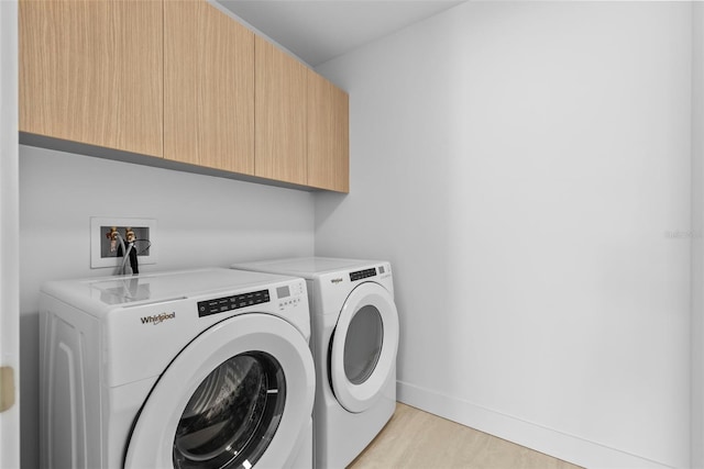 washroom featuring light wood finished floors, independent washer and dryer, cabinet space, and baseboards