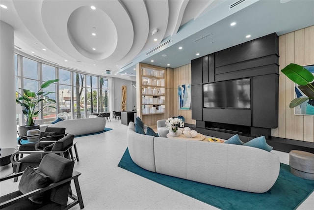 living room featuring wood walls, a wall of windows, visible vents, and recessed lighting