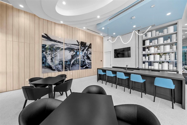 bar featuring wood walls, a sink, and recessed lighting