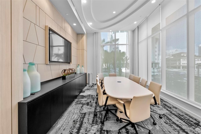 dining space featuring recessed lighting, a raised ceiling, floor to ceiling windows, and tile walls