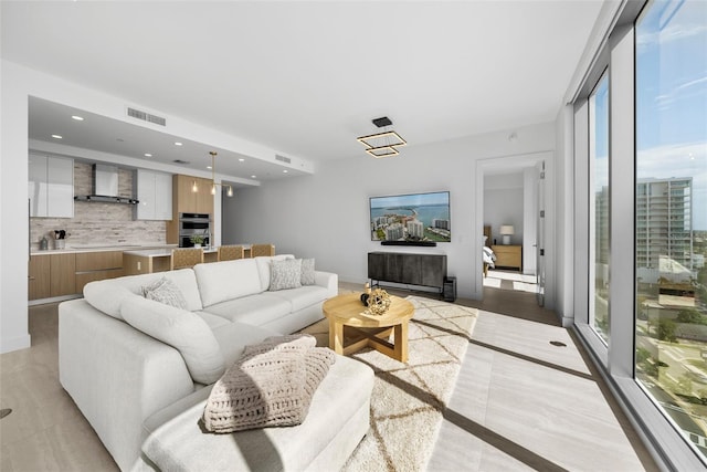 living area featuring baseboards, visible vents, and recessed lighting