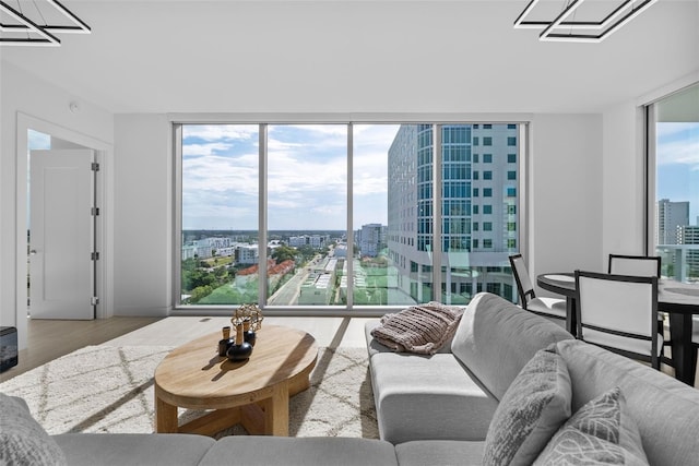 living area with a wealth of natural light, a view of city, expansive windows, and wood finished floors