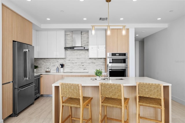 kitchen featuring wall chimney exhaust hood, modern cabinets, stainless steel appliances, light countertops, and backsplash