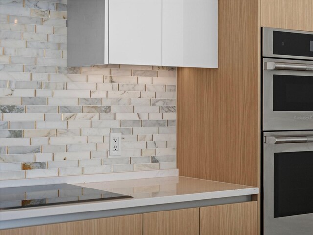 kitchen featuring double oven and light countertops