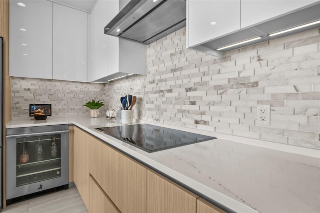 kitchen featuring tasteful backsplash, wall chimney exhaust hood, modern cabinets, wine cooler, and black electric stovetop