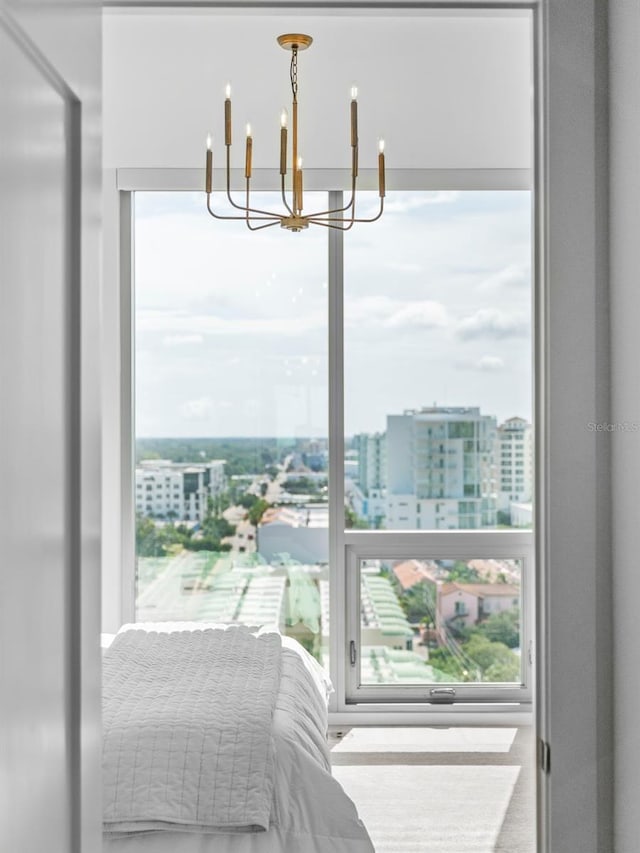 bedroom featuring a view of city and a chandelier