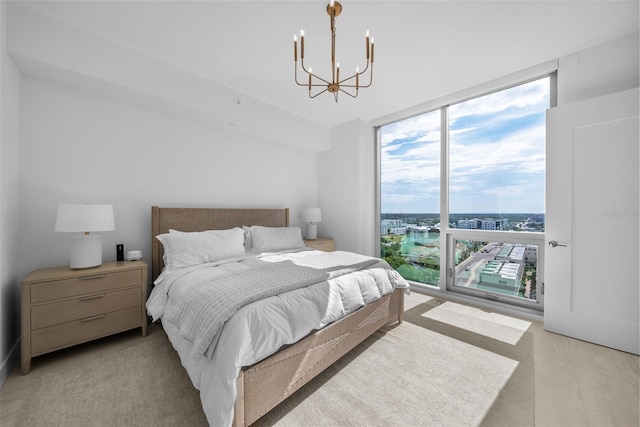 bedroom with a notable chandelier, a city view, and floor to ceiling windows