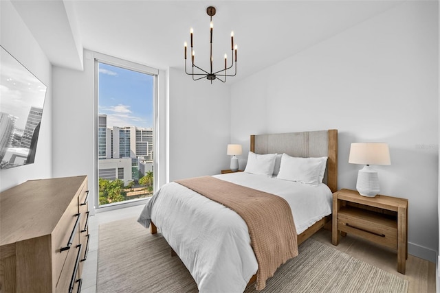 bedroom with a view of city, expansive windows, and a notable chandelier