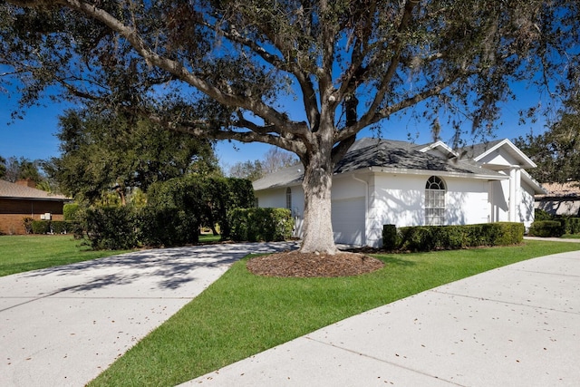 view of front of property featuring a garage, concrete driveway, and a front yard