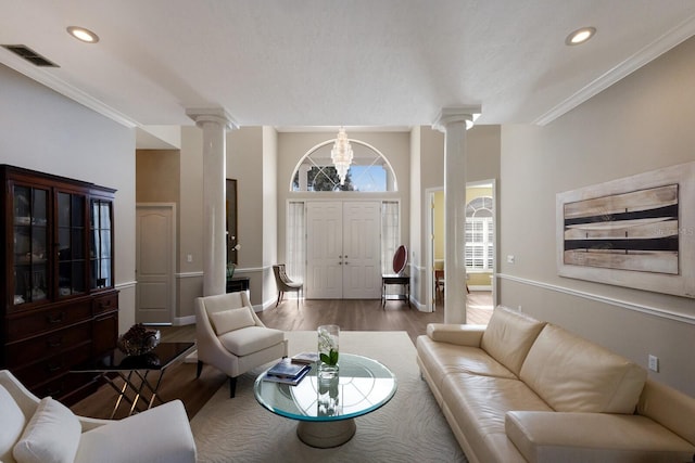 living area featuring recessed lighting, wood finished floors, visible vents, ornamental molding, and decorative columns