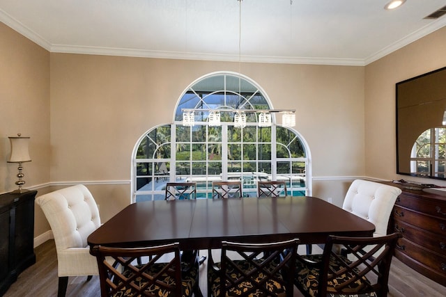 dining space with crown molding, visible vents, and wood finished floors