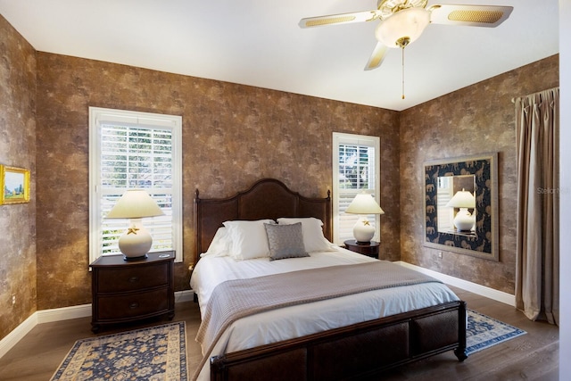 bedroom featuring a ceiling fan, baseboards, and wood finished floors