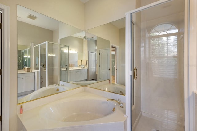 bathroom featuring visible vents, a garden tub, vanity, and a shower stall