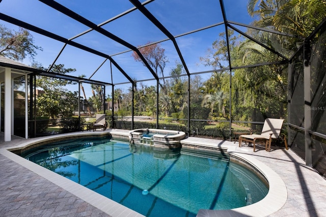 view of pool featuring glass enclosure, a patio area, and a pool with connected hot tub