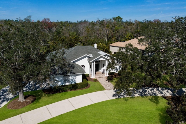 view of front of house featuring a front yard and a forest view