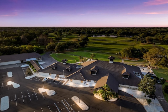 aerial view at dusk featuring view of golf course