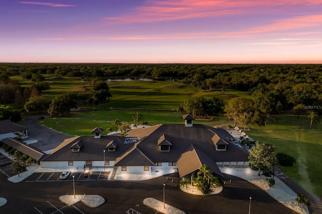 aerial view at dusk featuring view of golf course