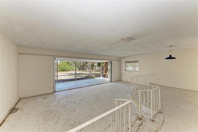 empty room featuring a healthy amount of sunlight and a textured ceiling