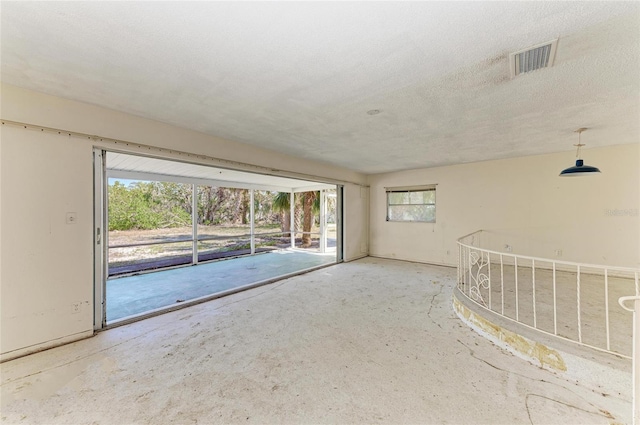 unfurnished room featuring a textured ceiling