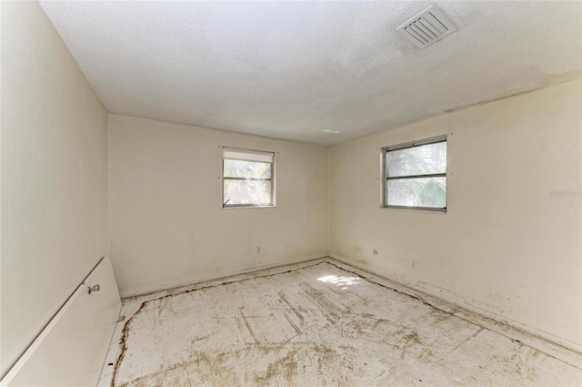 unfurnished room with a textured ceiling