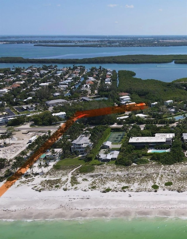 birds eye view of property featuring a water view and a beach view