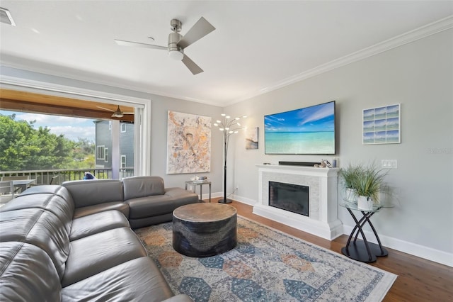 living room with ceiling fan, ornamental molding, and dark hardwood / wood-style flooring