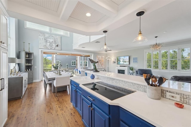 kitchen featuring beamed ceiling, coffered ceiling, blue cabinetry, and black electric cooktop