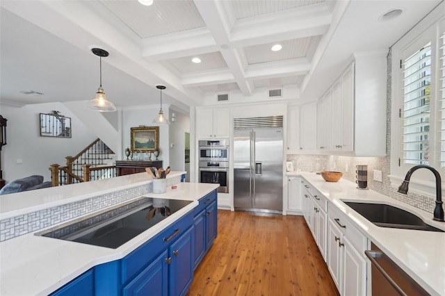 kitchen with sink, appliances with stainless steel finishes, white cabinetry, beam ceiling, and blue cabinets