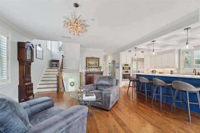 living room featuring beamed ceiling, sink, ornamental molding, coffered ceiling, and light hardwood / wood-style flooring