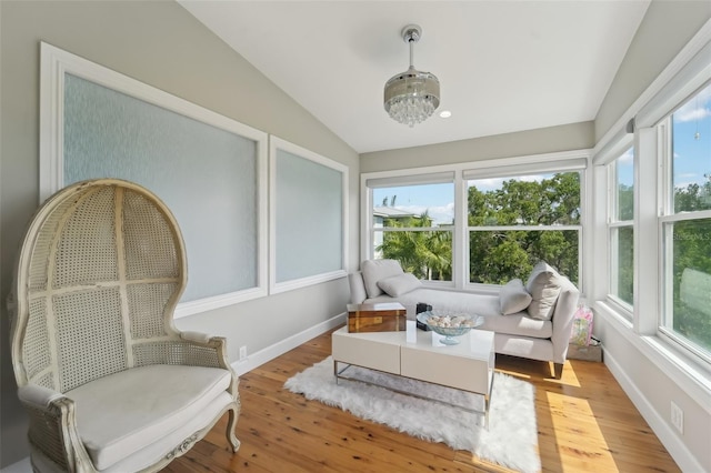 sunroom / solarium with lofted ceiling and an inviting chandelier