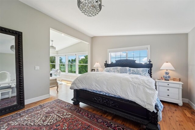 bedroom with lofted ceiling and light wood-type flooring