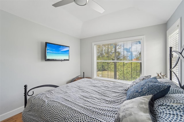 bedroom with hardwood / wood-style flooring, ceiling fan, and multiple windows