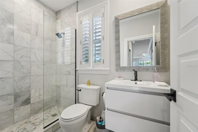 bathroom featuring tiled shower, vanity, and toilet