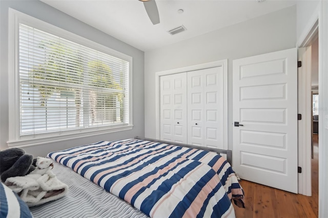 bedroom featuring dark wood-type flooring, ceiling fan, and a closet