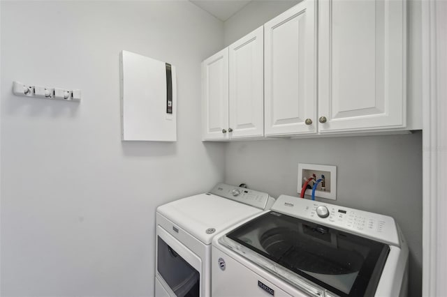 laundry area featuring cabinets, electric panel, and washer and dryer