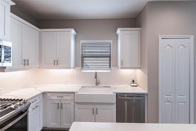 kitchen featuring sink, stainless steel appliances, white cabinets, and light stone countertops