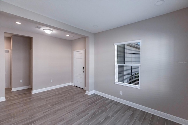 unfurnished room with hardwood / wood-style flooring