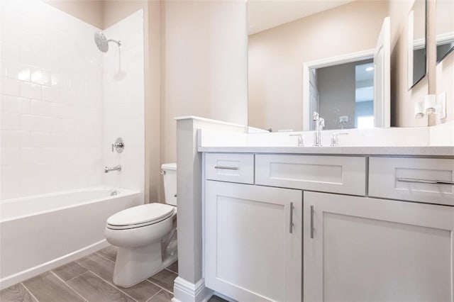 full bathroom with tiled shower / bath, vanity, and toilet