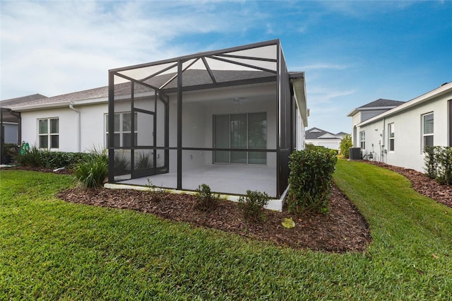 rear view of house featuring a lanai, a yard, central AC unit, and a patio area