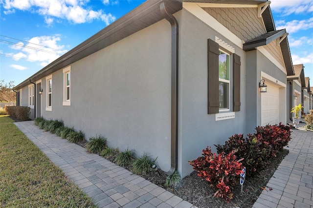 view of property exterior with an attached garage and stucco siding