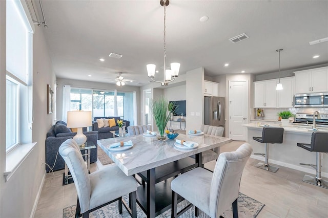 dining space with ceiling fan with notable chandelier, recessed lighting, visible vents, and baseboards