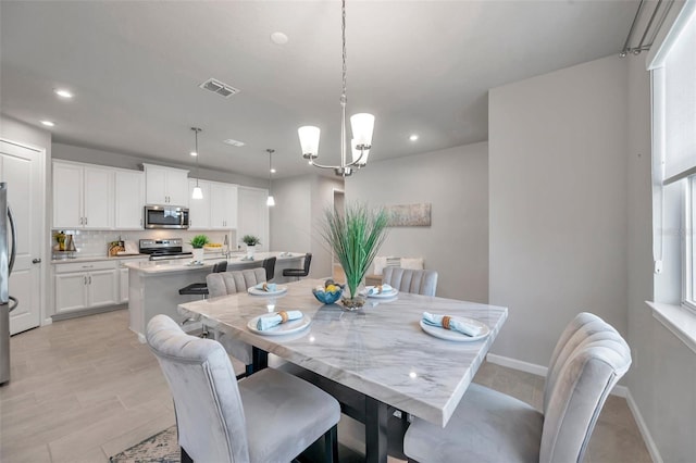 dining room featuring baseboards, visible vents, a notable chandelier, and recessed lighting