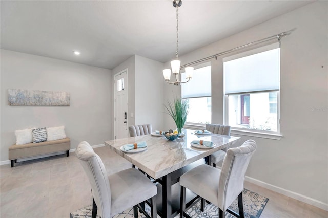 tiled dining room with a notable chandelier