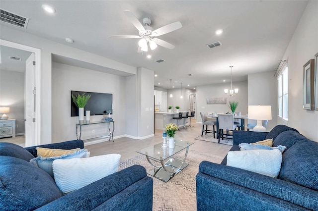 living room with ceiling fan with notable chandelier