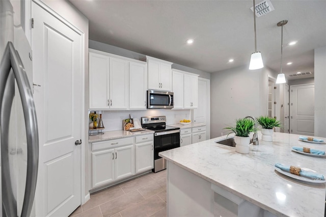 kitchen featuring light stone counters, stainless steel appliances, visible vents, white cabinetry, and decorative light fixtures